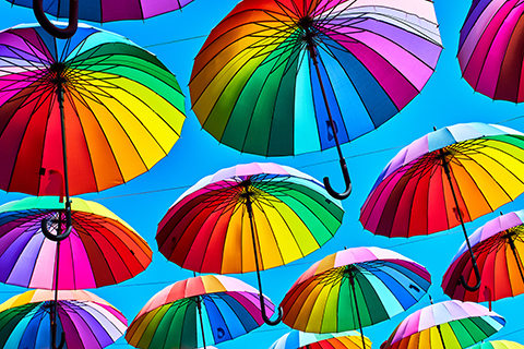 A close up photo of colorful umbrellas suspended in the air.
